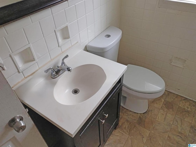 bathroom with decorative backsplash, vanity, toilet, and tile walls