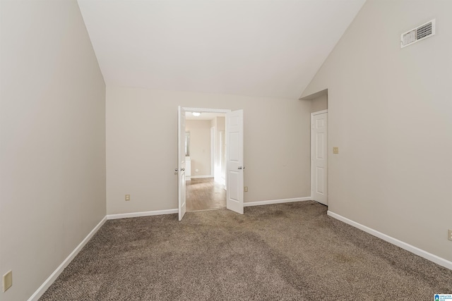 unfurnished bedroom featuring carpet flooring and lofted ceiling