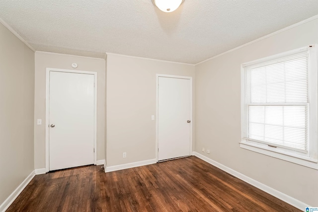 unfurnished bedroom featuring a textured ceiling, dark hardwood / wood-style flooring, and crown molding