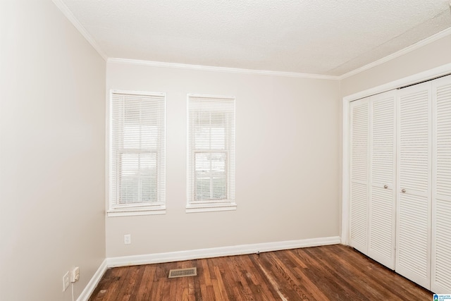 unfurnished bedroom featuring a closet, dark wood-type flooring, and ornamental molding