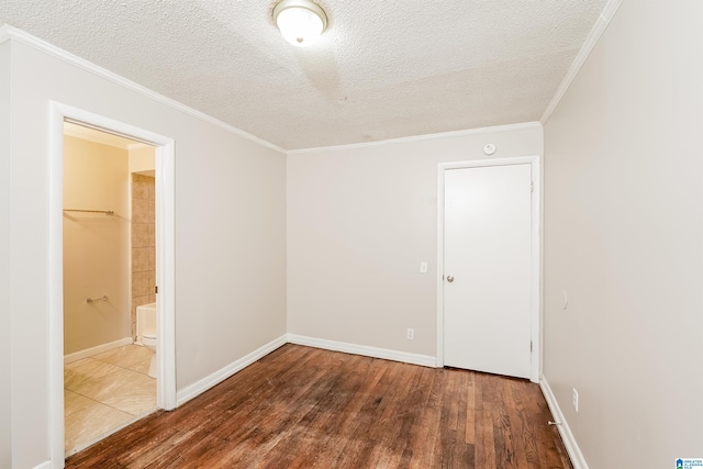 unfurnished room featuring a textured ceiling, crown molding, and dark wood-type flooring