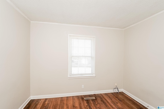 empty room featuring a wealth of natural light, wood-type flooring, a textured ceiling, and ornamental molding