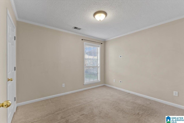 spare room with light colored carpet, ornamental molding, and a textured ceiling