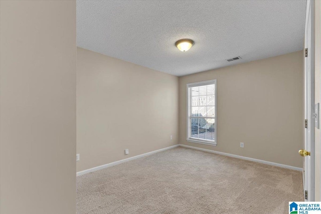 carpeted spare room with a textured ceiling