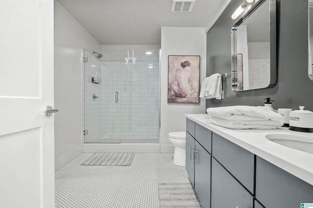 bathroom featuring toilet, vanity, tile patterned floors, and walk in shower