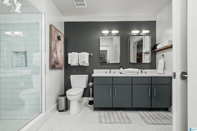 bathroom featuring tiled shower, tile patterned floors, vanity, and toilet