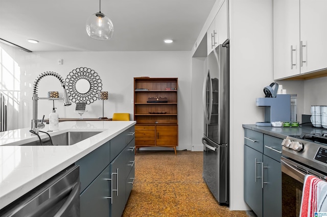 kitchen with decorative light fixtures, stainless steel appliances, white cabinetry, and sink