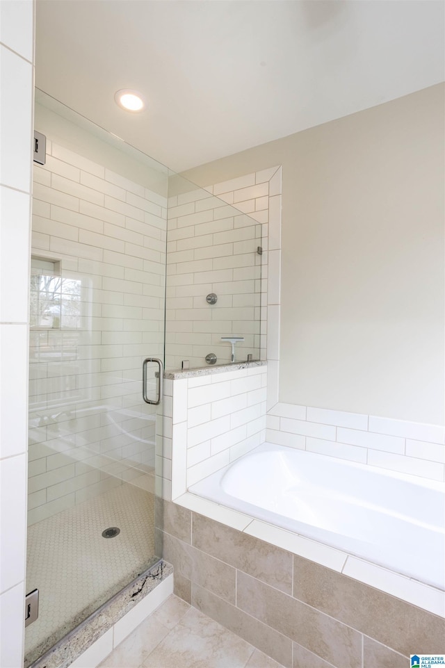 bathroom with tile patterned flooring and separate shower and tub