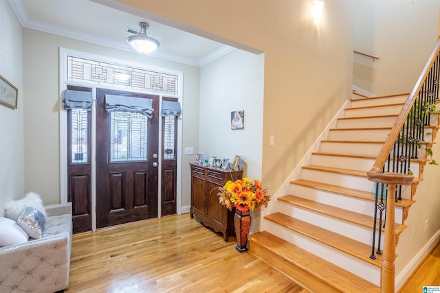 entryway featuring light wood-type flooring and crown molding