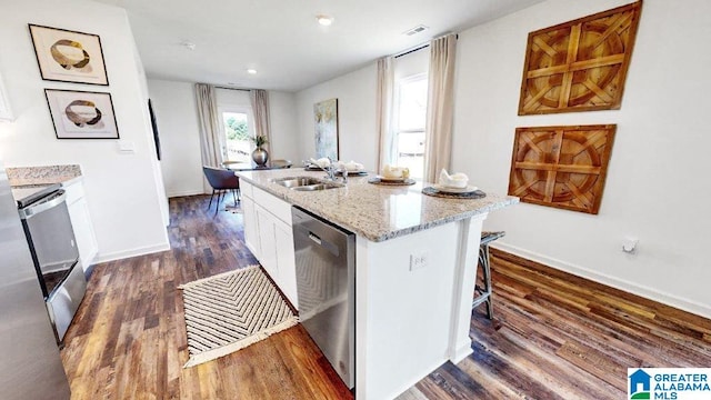 kitchen with dishwasher, sink, stove, a center island with sink, and white cabinets