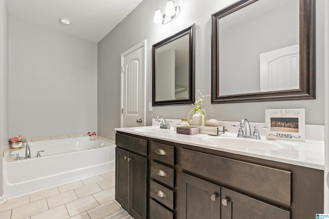 bathroom featuring tile patterned floors, a washtub, and vanity