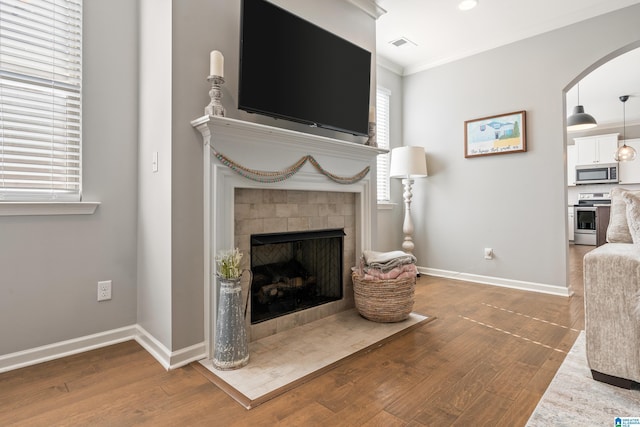 living room with hardwood / wood-style flooring, plenty of natural light, and crown molding