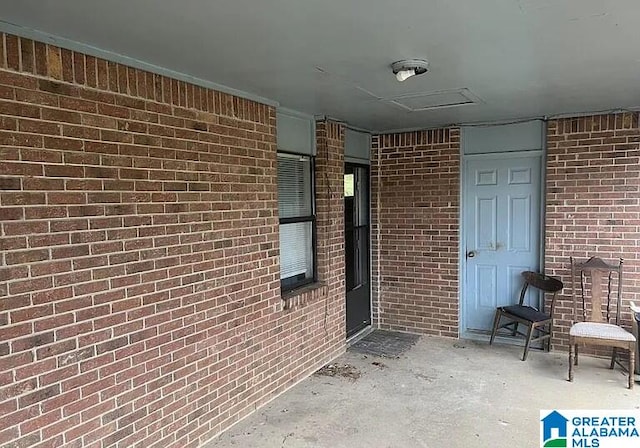 view of exterior entry with a patio area