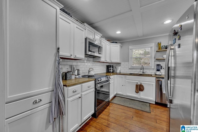 kitchen featuring sink, tasteful backsplash, light hardwood / wood-style floors, white cabinetry, and stainless steel appliances