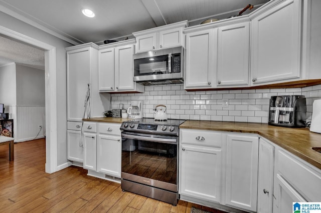 kitchen with white cabinets, wood counters, light hardwood / wood-style floors, and stainless steel appliances