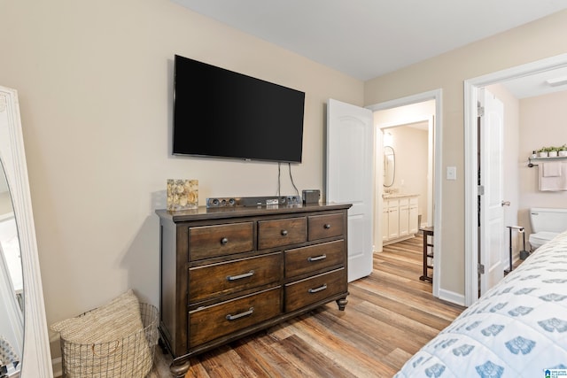 bedroom featuring light hardwood / wood-style floors and ensuite bath