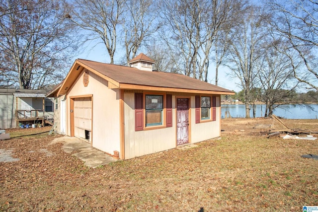 exterior space with a water view, a garage, and an outdoor structure