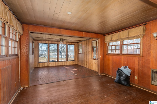 spare room featuring wooden walls, dark hardwood / wood-style flooring, ceiling fan, and wooden ceiling