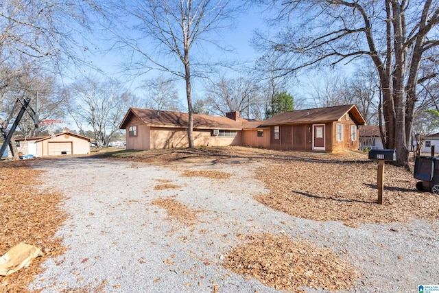 single story home featuring an outbuilding and a garage