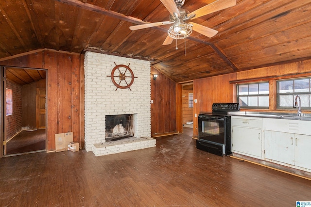 kitchen featuring a brick fireplace, vaulted ceiling, sink, electric range, and wood walls