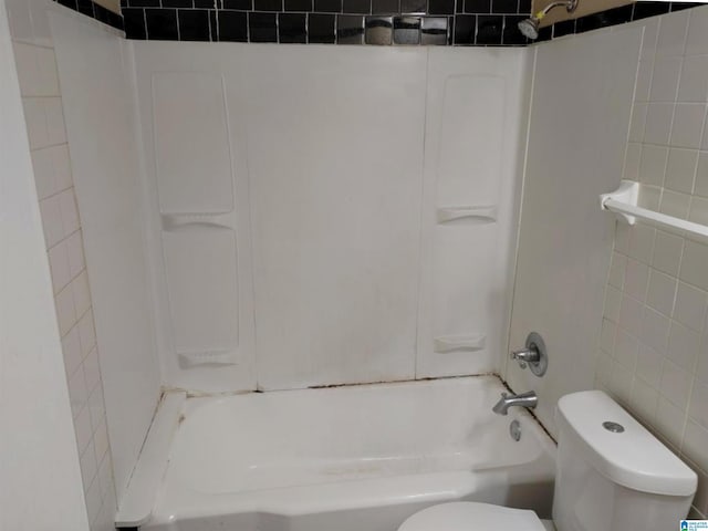 bathroom with toilet, shower / tub combination, and tile walls