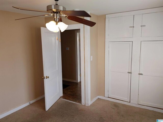 unfurnished bedroom with carpet flooring, ceiling fan, and a closet