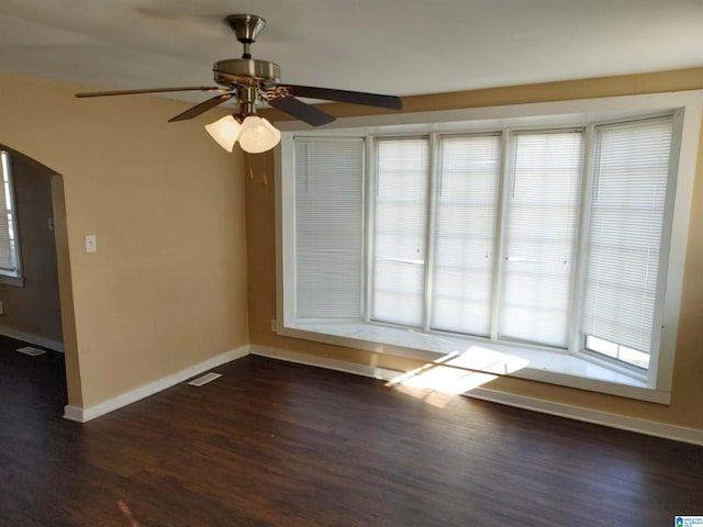 spare room with dark hardwood / wood-style flooring and ceiling fan