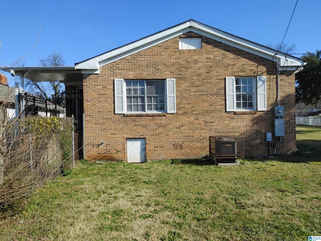 view of side of home with central AC and a yard