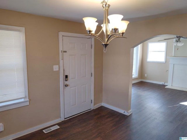 entrance foyer with ceiling fan with notable chandelier and dark hardwood / wood-style floors