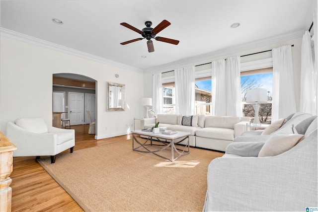 living room with hardwood / wood-style floors, ceiling fan, and crown molding