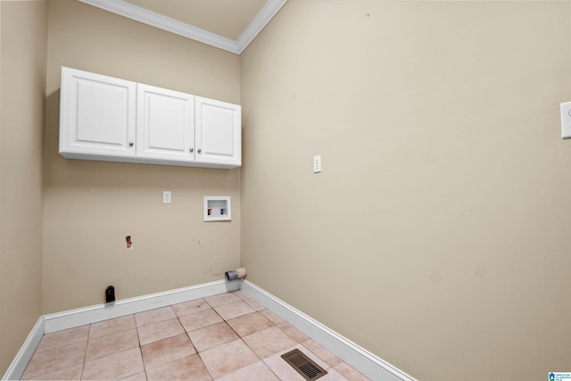 clothes washing area with washer hookup, cabinets, light tile patterned floors, and crown molding