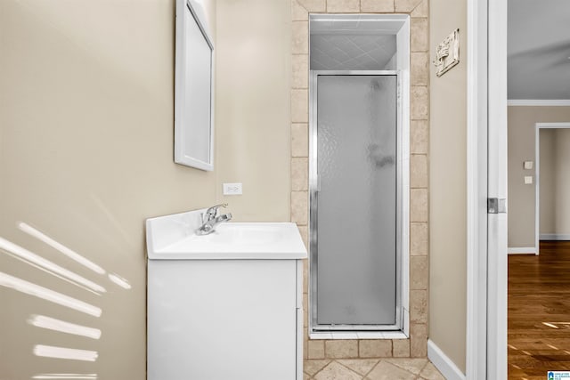 bathroom with vanity, an enclosed shower, and ornamental molding