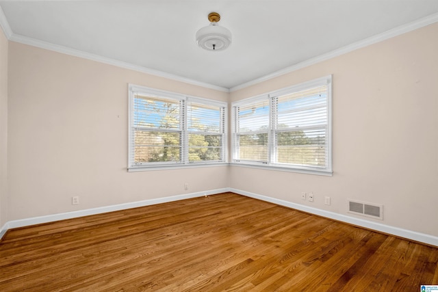 spare room featuring hardwood / wood-style floors and crown molding