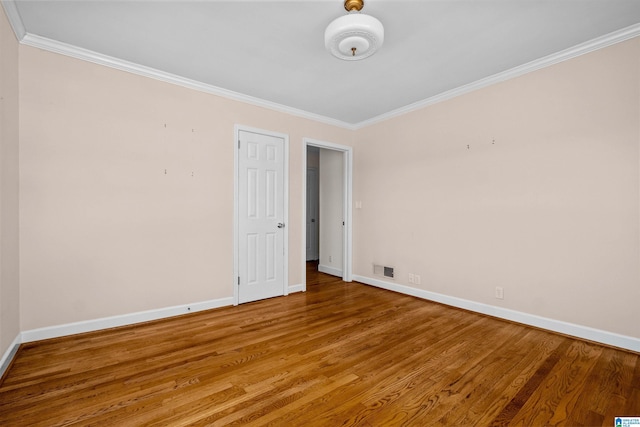 unfurnished room with hardwood / wood-style flooring and crown molding