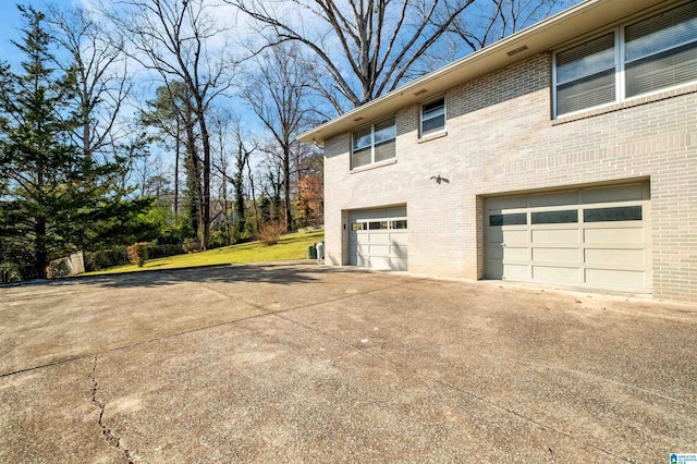 view of side of home featuring a garage and a yard