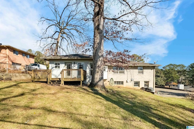 rear view of house with a yard and a deck