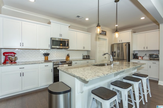 kitchen featuring sink, stainless steel appliances, backsplash, a kitchen island with sink, and white cabinets