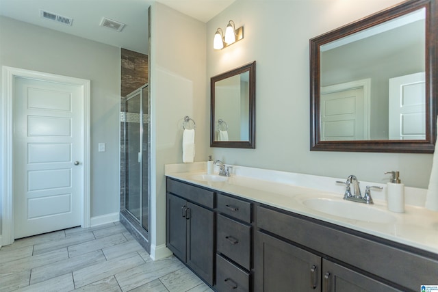 bathroom with a shower with door and vanity