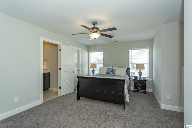 bedroom with ceiling fan, carpet floors, and ensuite bath