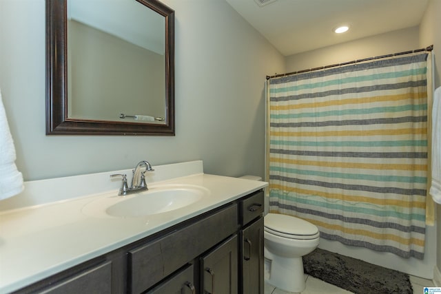 bathroom featuring tile patterned flooring, vanity, toilet, and walk in shower