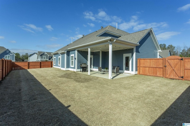 back of house with a patio area and a yard