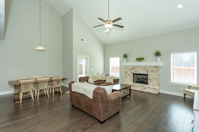 living room featuring dark hardwood / wood-style flooring, ceiling fan, a fireplace, and high vaulted ceiling