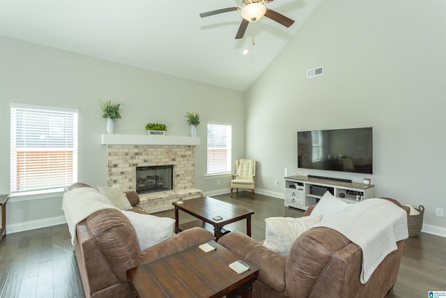 living room with dark hardwood / wood-style floors, ceiling fan, a fireplace, and high vaulted ceiling