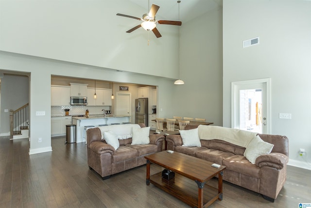 living room featuring ceiling fan, dark hardwood / wood-style flooring, and high vaulted ceiling