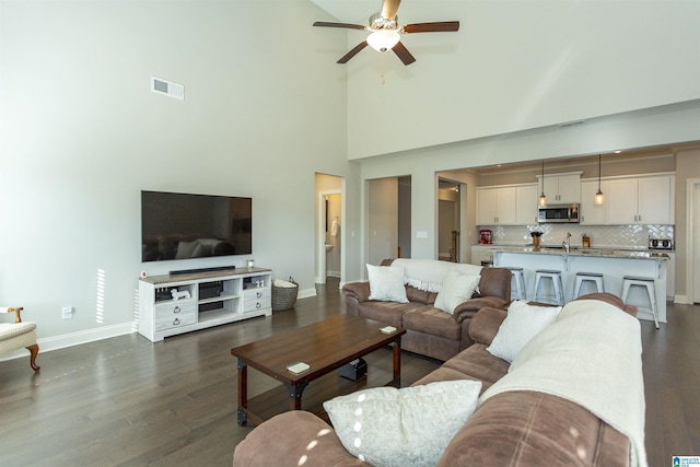 living room with dark hardwood / wood-style floors, high vaulted ceiling, and ceiling fan