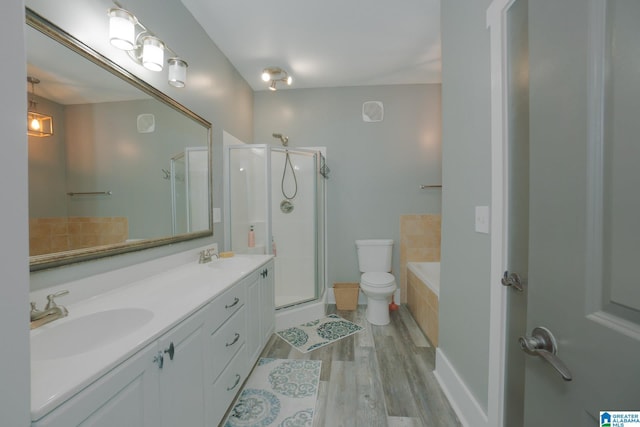 full bathroom with hardwood / wood-style flooring, vanity, toilet, and plus walk in shower