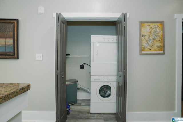 washroom with stacked washer / dryer and dark wood-type flooring