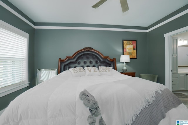 bedroom with hardwood / wood-style floors, ceiling fan, and ensuite bath