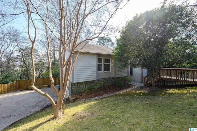 view of side of property featuring a yard and a wooden deck