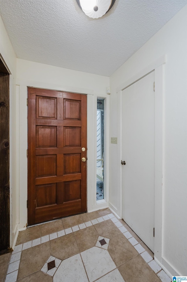 tiled foyer entrance with a textured ceiling